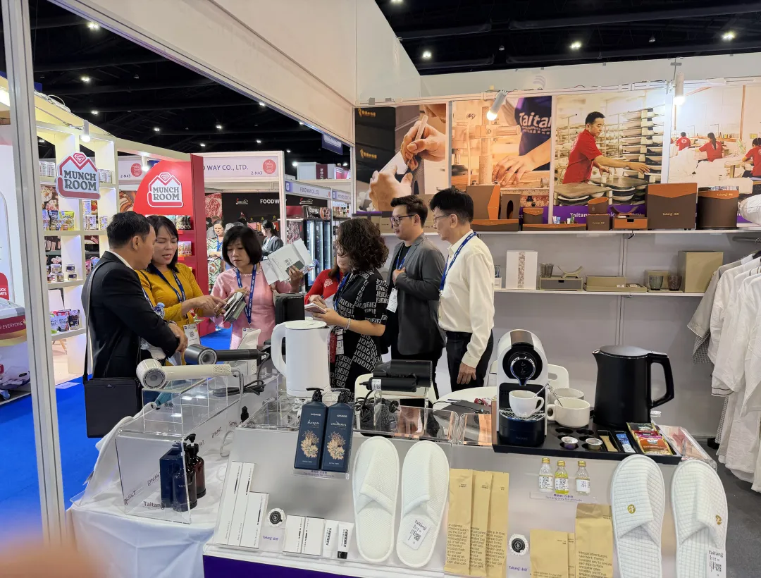 Taitang staff demonstrating eco-friendly guestroom amenities and kraft paper packaging to Southeast Asian hospitality buyers.