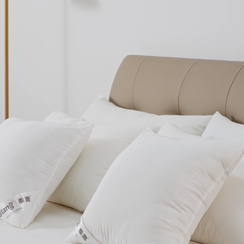 Taitang luxury hotel pillows with custom woven brand label arranged on a commercial guest room bed.png