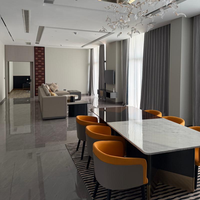 Executive VIP conference dining room featuring a sleek marble table, custom orange leather chairs, and modern chandelier.jpg