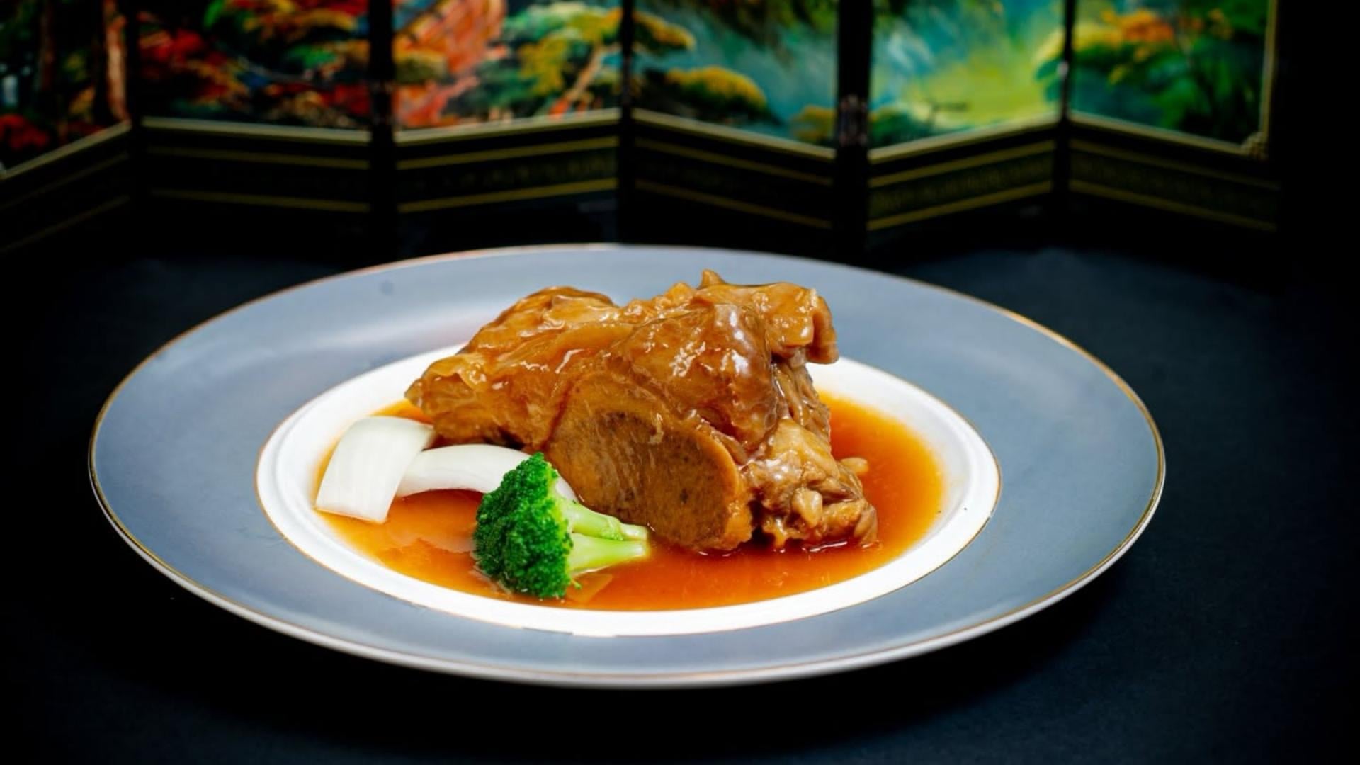 Gourmet braised meat dish elegantly served on a commercial white ceramic dinner plate for fine dining service.jpg