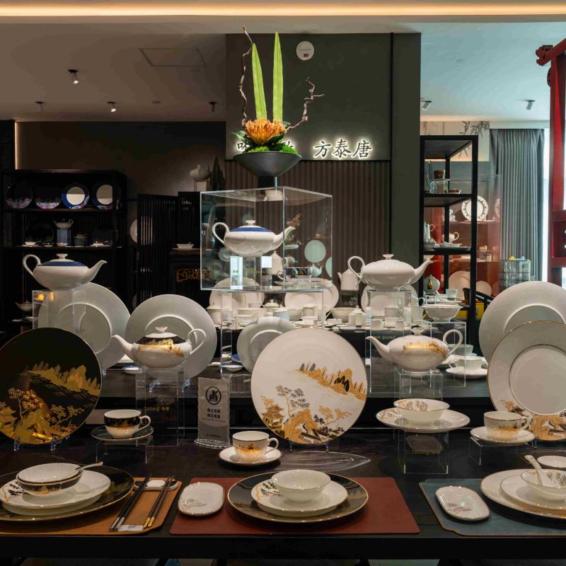 Elaborate Chinese fine dining porcelain tableware display featuring gold accents and detailed artwork on a banquet table.jpg