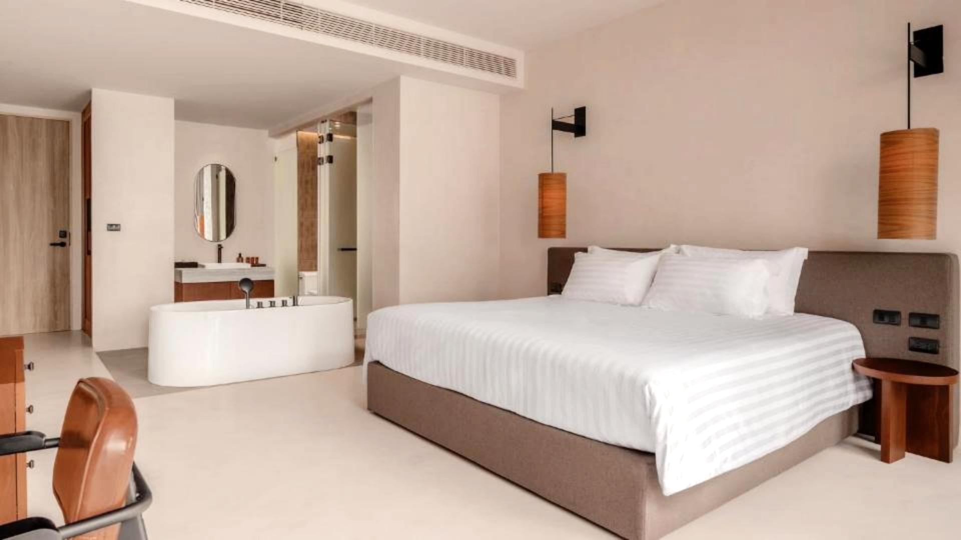 Modern resort guestroom interior featuring open bathroom vanity and styled king bed at Hykyo River Kwai Hotel.jpg