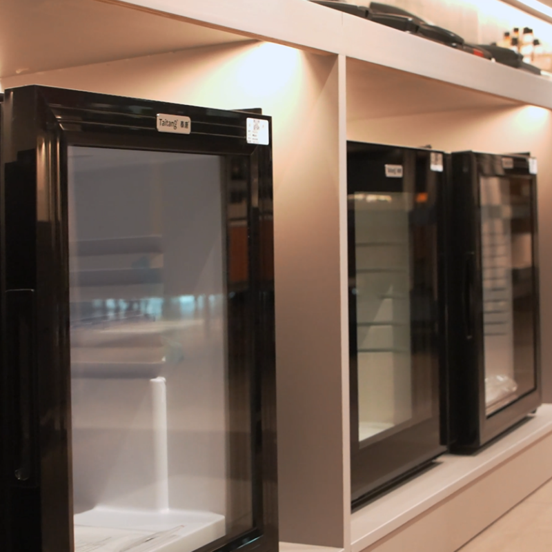 Taitang ultra-quiet glass door hotel mini fridges on display in a modern showroom for guest room FF&E procurement.png