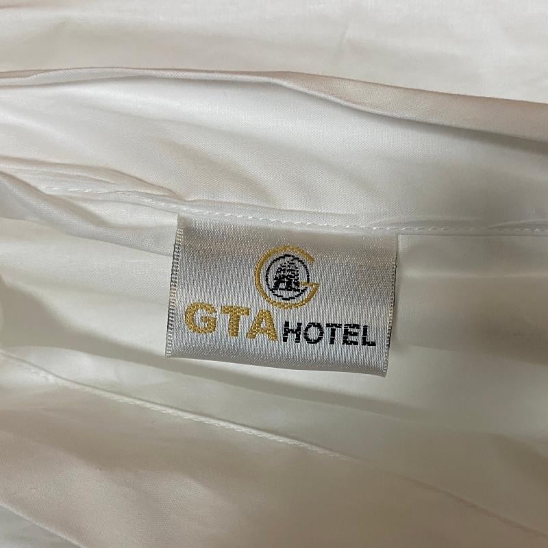 Close-up of high-thread-count white duvet cover featuring a custom-woven GTA HOTEL brand label.JPG