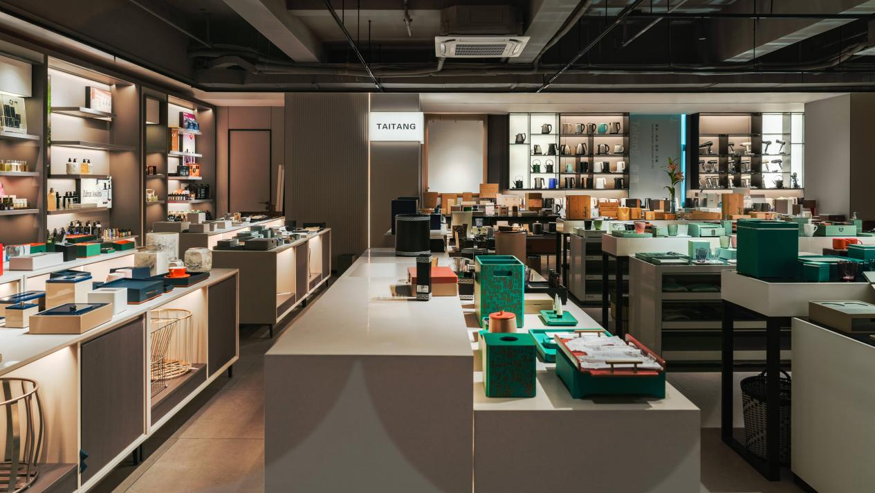 A well-lit interior of a Taitang showroom featuring diverse guest room supplies, including electric kettles, hair dryers, eco-friendly amenity kits, and organized hotel leather collections.
