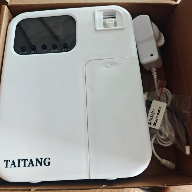 White electronic hotel room fragrance dispenser branded with Taitang logo undergoing factory QA check.jpg