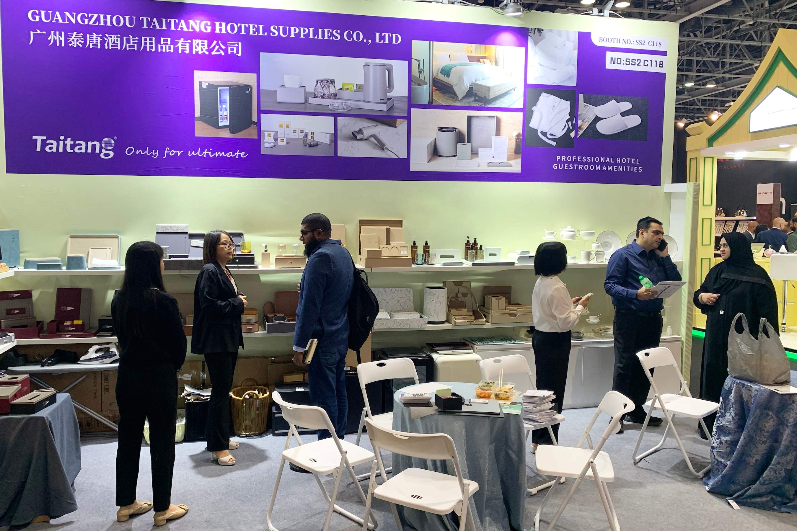 A group of professional buyers consulting with the TAITANG exhibition team about customized hotel service upgrade solutions and product quality.