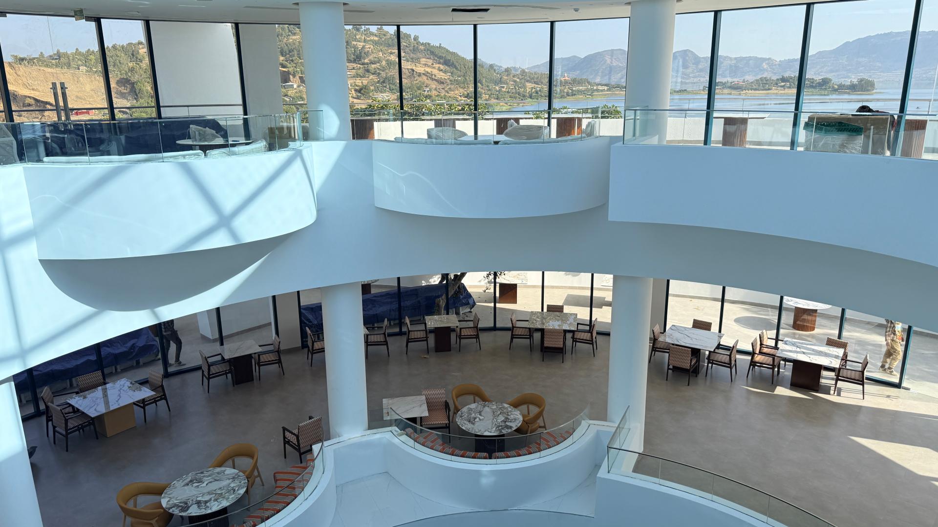Multi-level resort atrium architectural layout overlooking lower-floor lounge and dining spaces.jpg