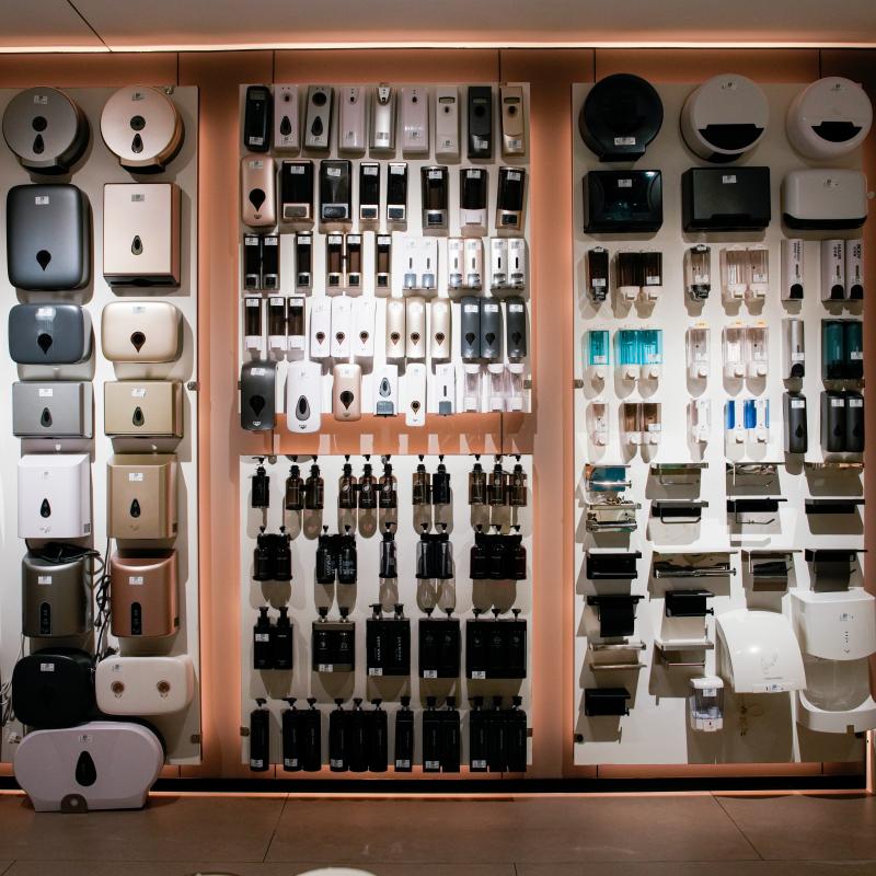 Wall display of commercial bathroom dispensers, touchless soap solutions, and automated public restroom hardware for high-traffic hotels.JPG