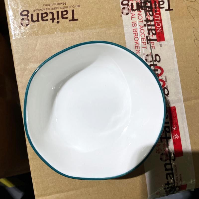 Durable white ceramic bowl with a subtle green rim resting on a Taitang branded carton during factory quality inspection.JPG