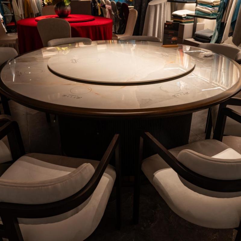 A circular, polished stone lazy susan tabletop in a luxury hotel dining suite, showcasing bespoke design and fine craftsmanship.jpg