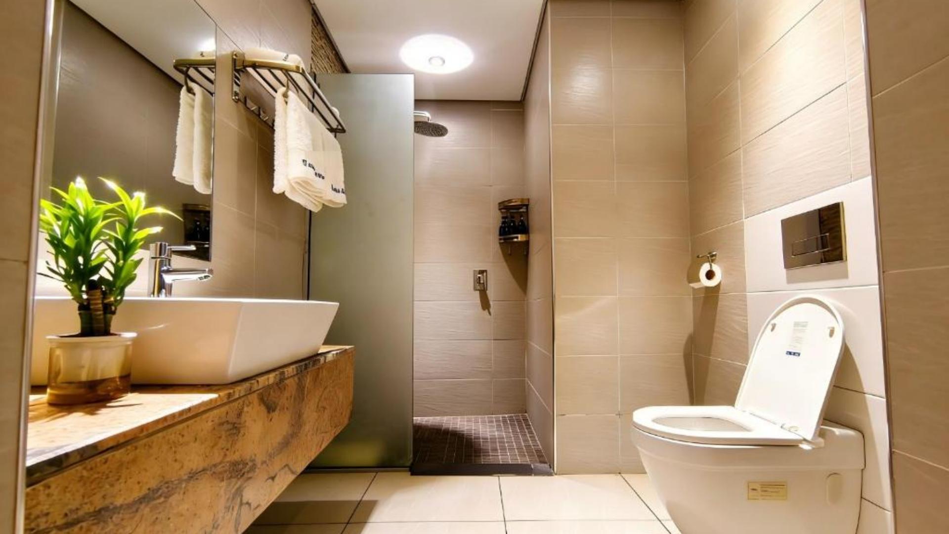 Modern luxury hotel bathroom with wooden vanity counter, vessel sink, and bright interior lighting.jpg