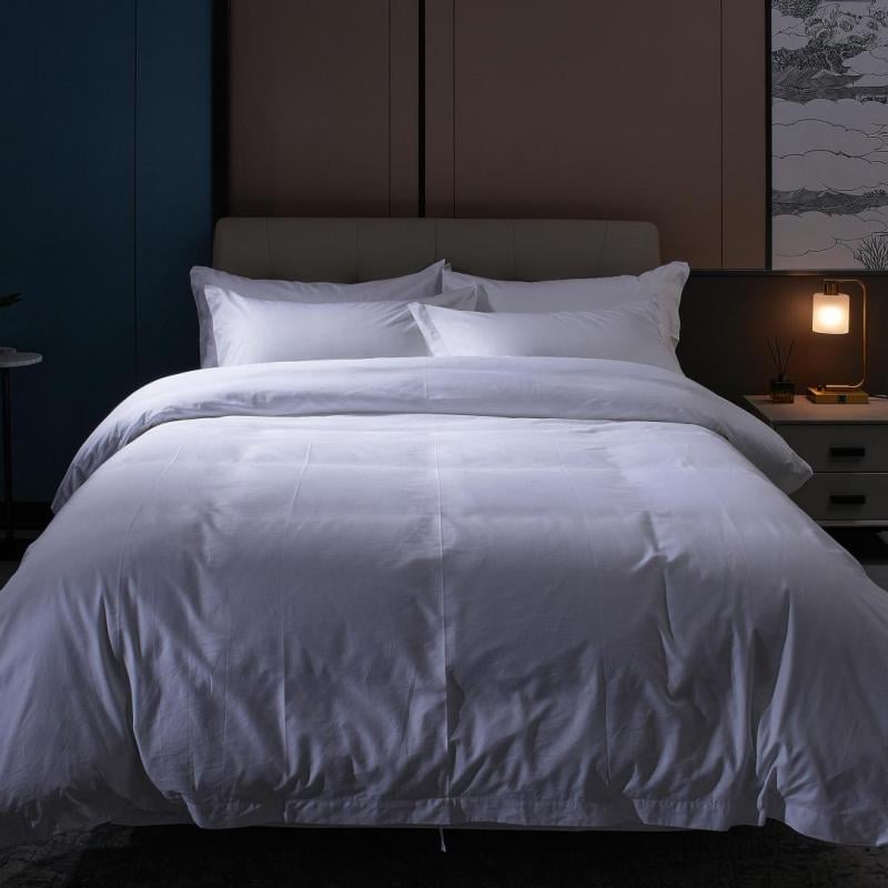 Luxury hotel room featuring complete bed assembly with white duvet and pillows for Taitang B2B bedding procurement guide.jpg