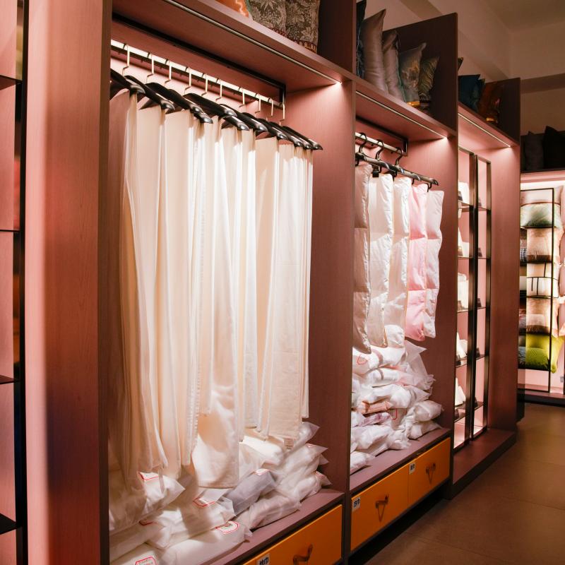 Taitang commercial hotel linen and bedding accessories organized on illuminated retail-style showroom racks.JPG