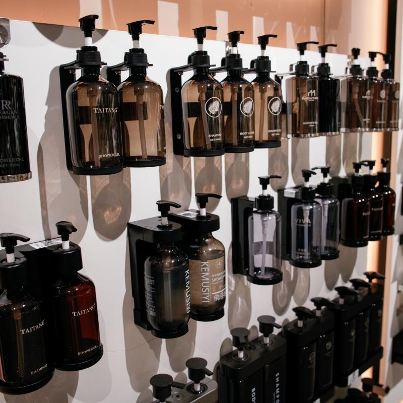 Commercial showroom display wall featuring various Taitang wall-mounted hotel soap and shampoo dispenser models.JPG