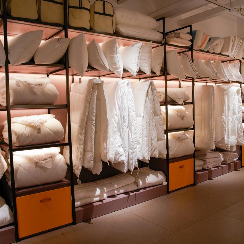 Taitang wholesale hotel bedding showroom display featuring commercial white goose down duvets and plush microfibre pillows for luxury hotels.JPG