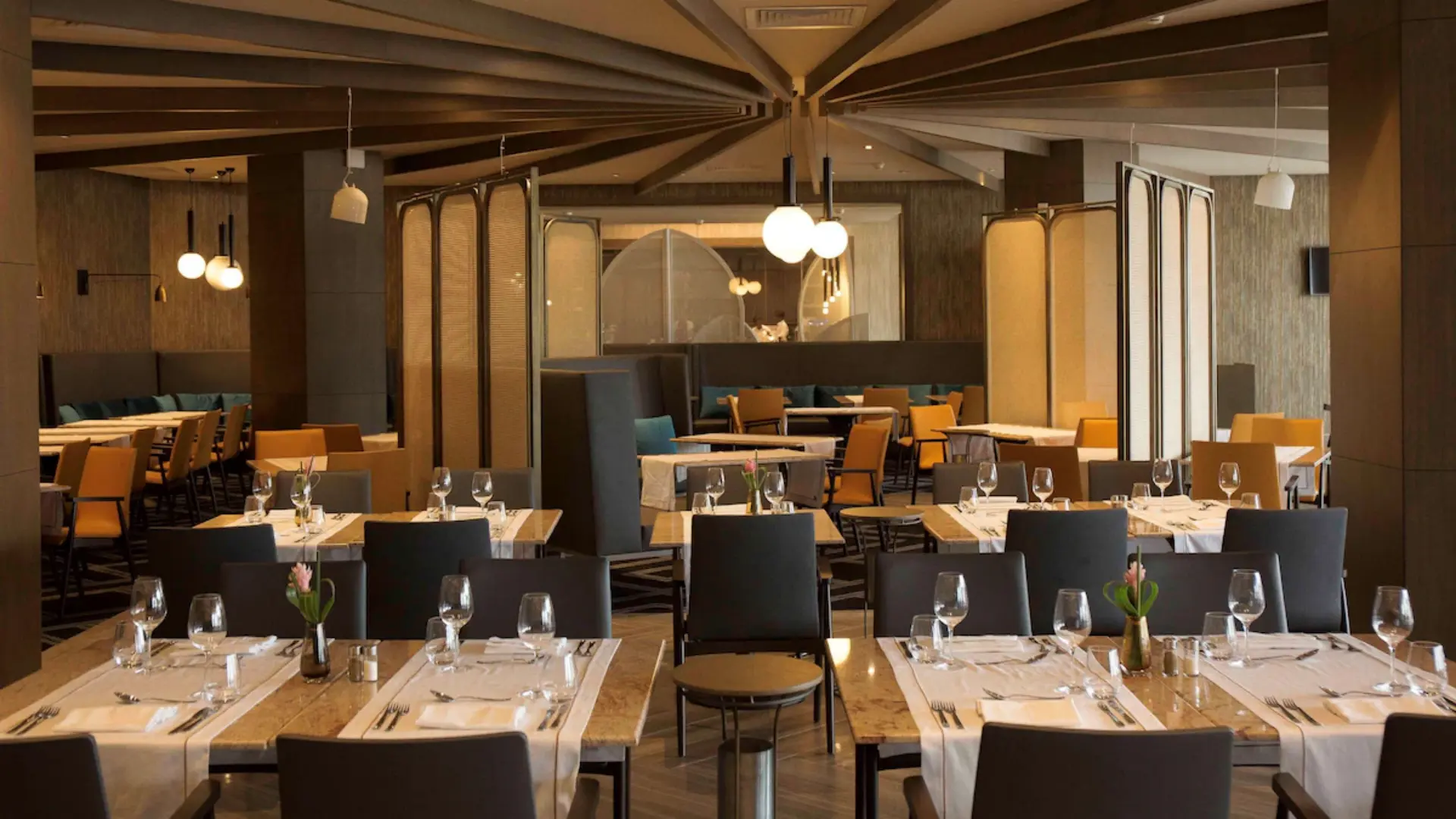 Larder Restaurant interior showing dining tables set with fine tableware and crystal glasses at Radisson Blu Hotel Abidjan Airport.webp
