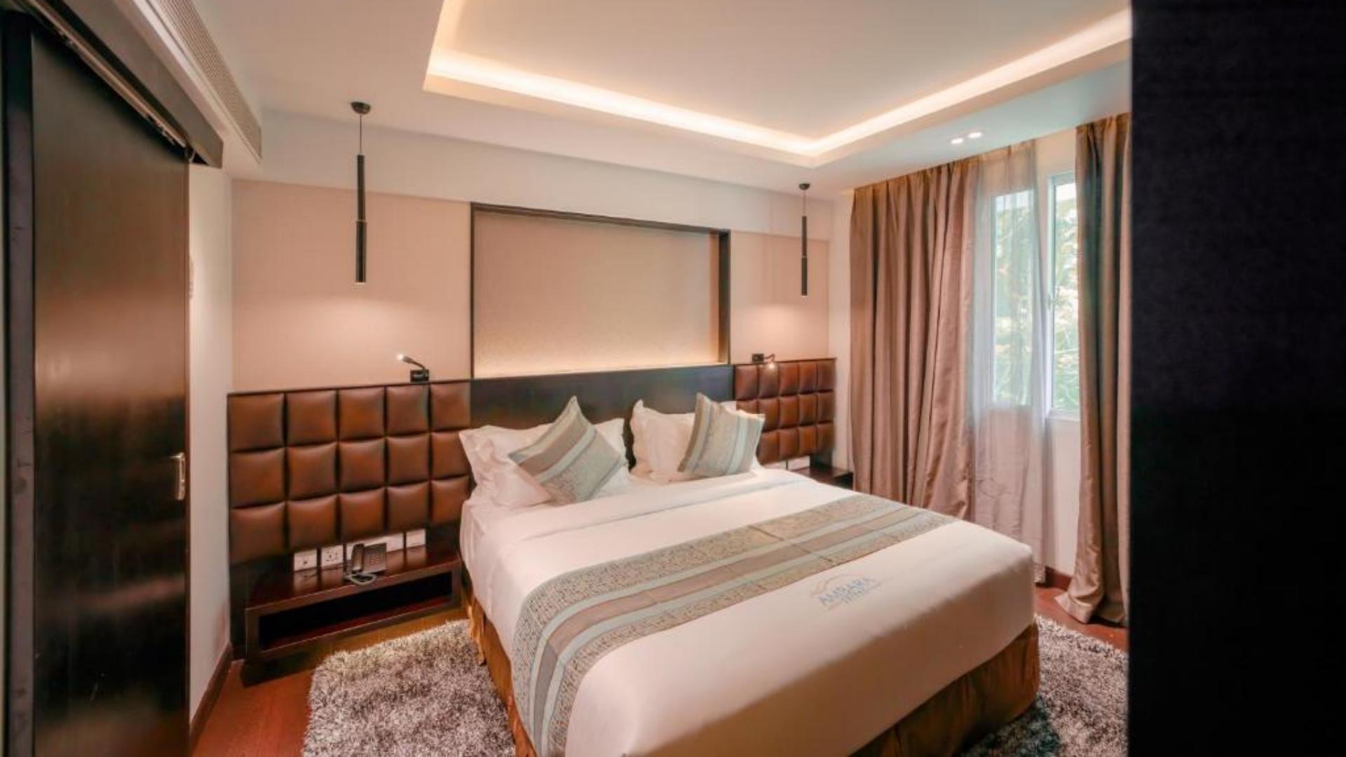 Luxury hotel guestroom with a custom bed runner styling a plush king bed at Ambara Suites.jpg