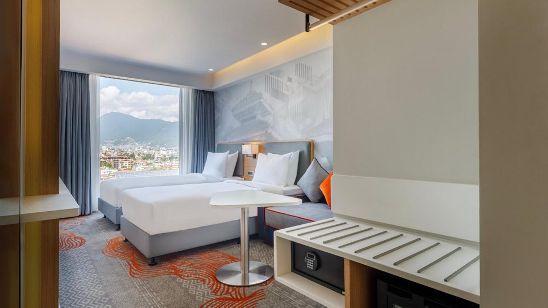 Modern 4-star twin guestroom interior featuring clean white bedding, luggage rack, and scenic city views.jpg