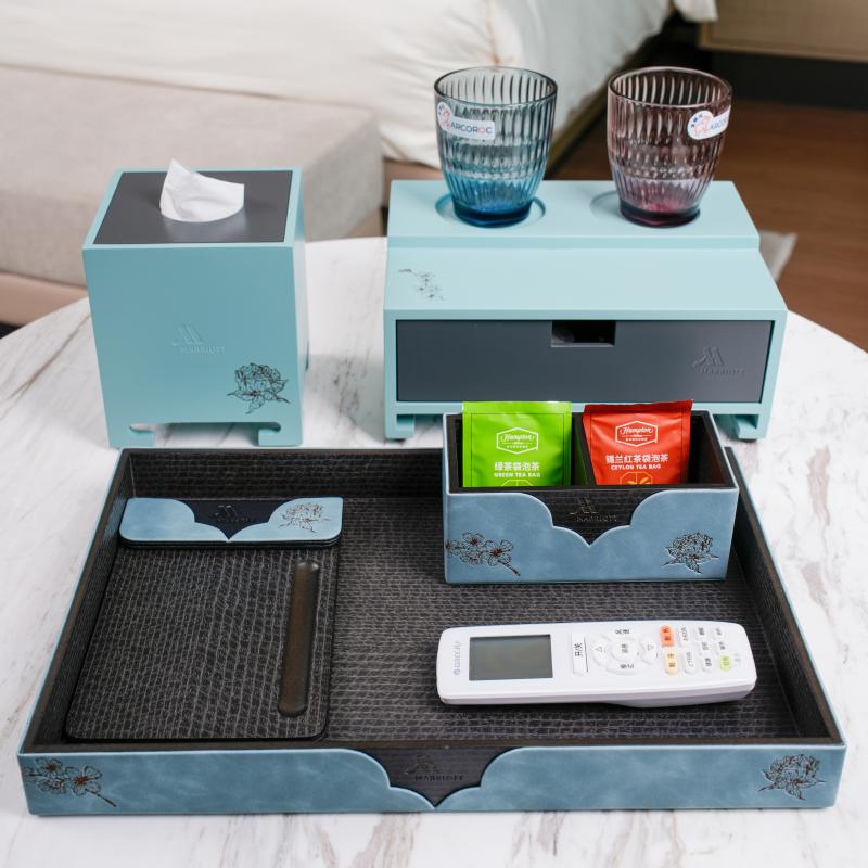 A luxury light blue hotel room amenities tray set by Taitang featuring a matching square tissue box, a raised tea station with glass tumblers, a remote control holder, and an organized sachet box.JPG