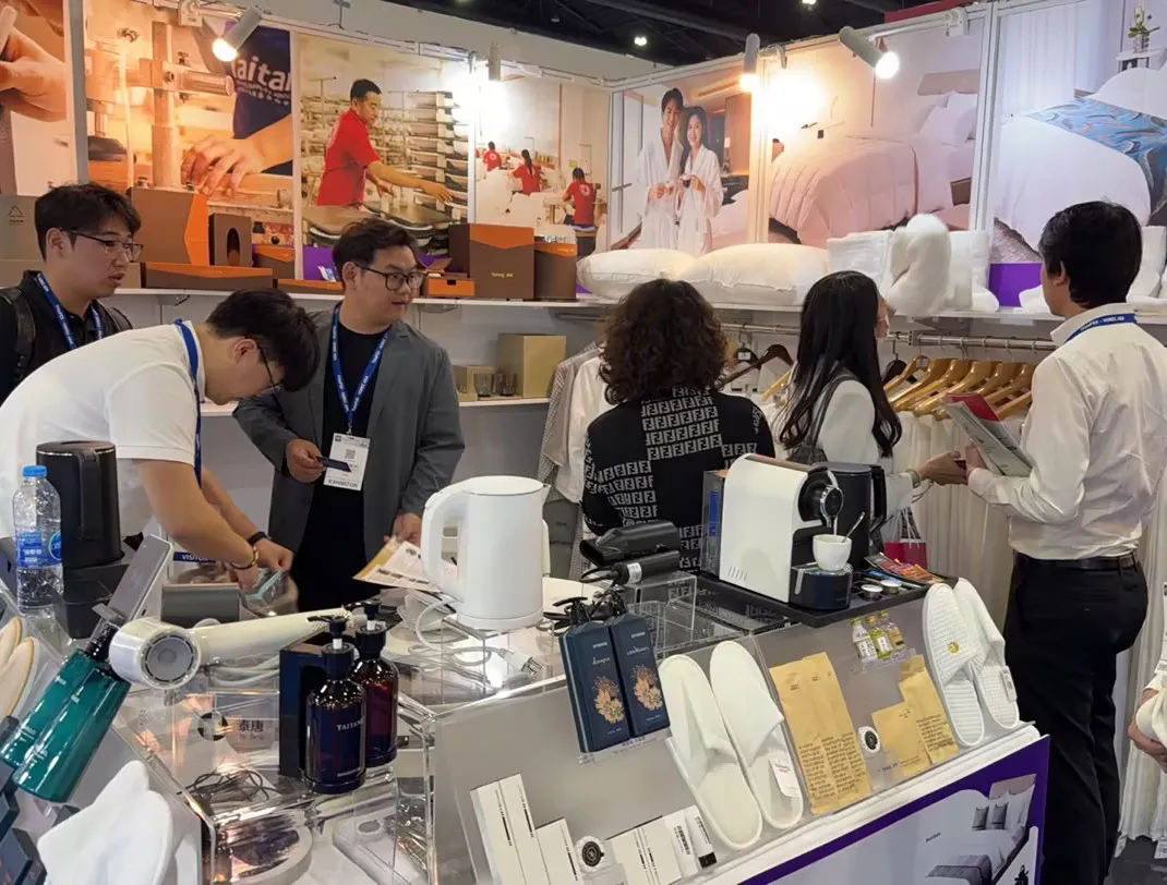 Detailed view of the Taitang booth featuring premium hotel linens, bathrobes, and small appliances on display for hotel owners.
