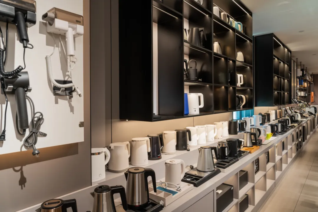 A comprehensive collection of hotel room small appliances including professional hair dryers and various electric kettle models in the Taitang showroom.