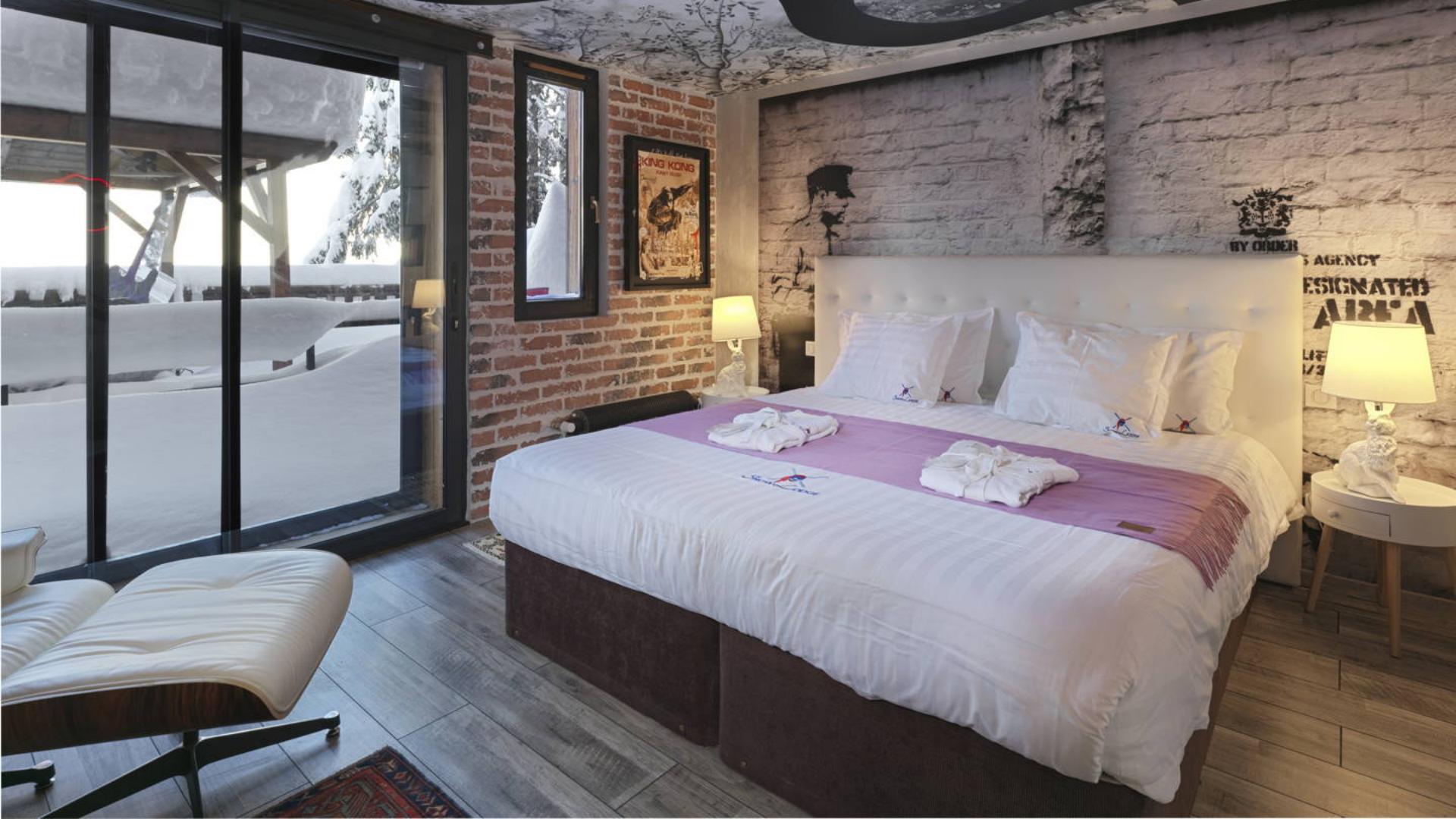 Custom boutique hotel bedding and plush towels supplied by Taitang on a modern luxury king-size bed in a rustic alpine suite at Snow Lodge Hotel.jpg