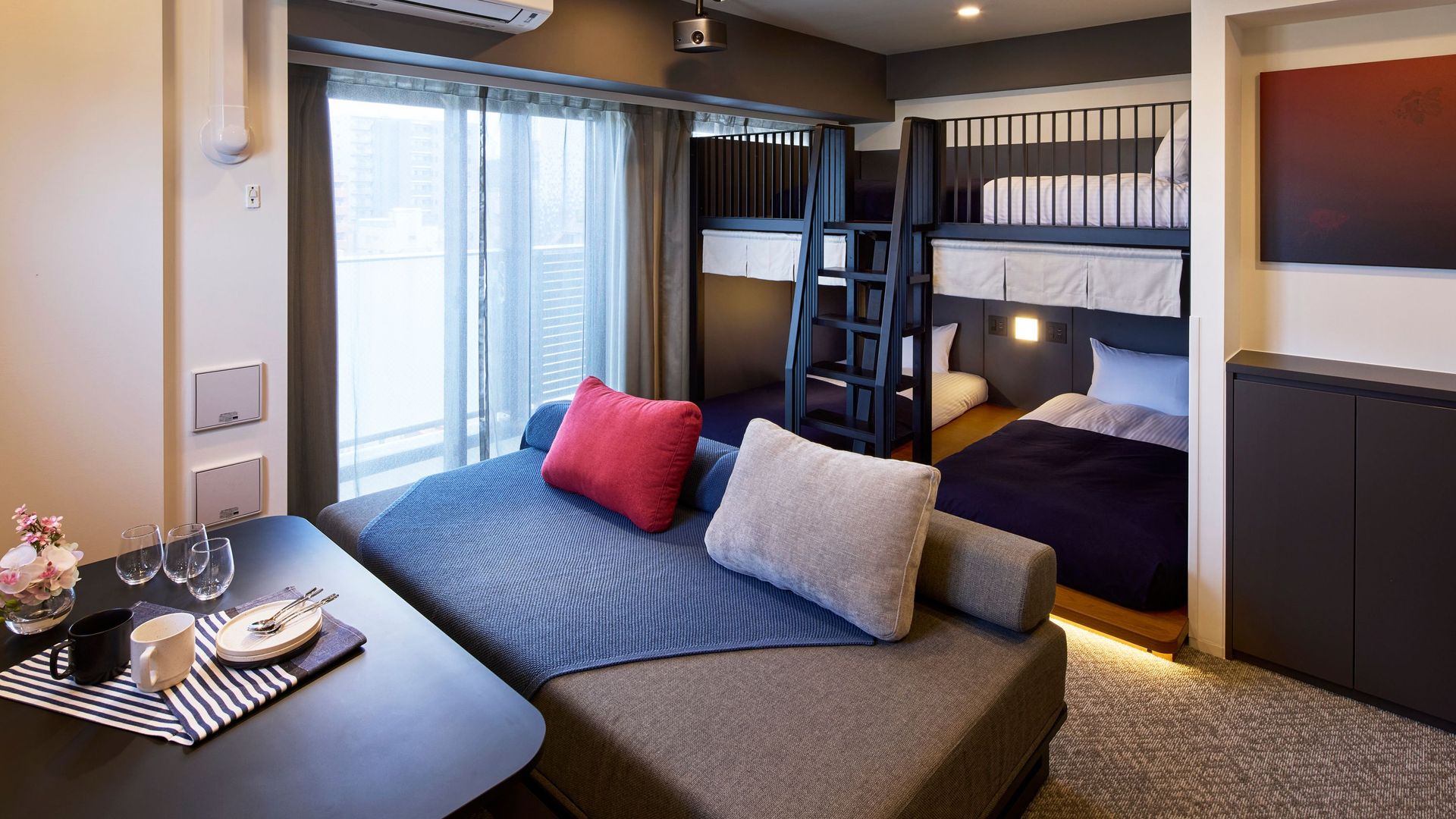 Boutique hotel apartment family room interior featuring plush sofa seating and wooden bunk beds.jpg