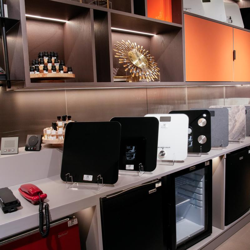 Taitang hotel showroom displaying guest room appliances including built-in absorption minibars, digital scales, and room telephones.JPG