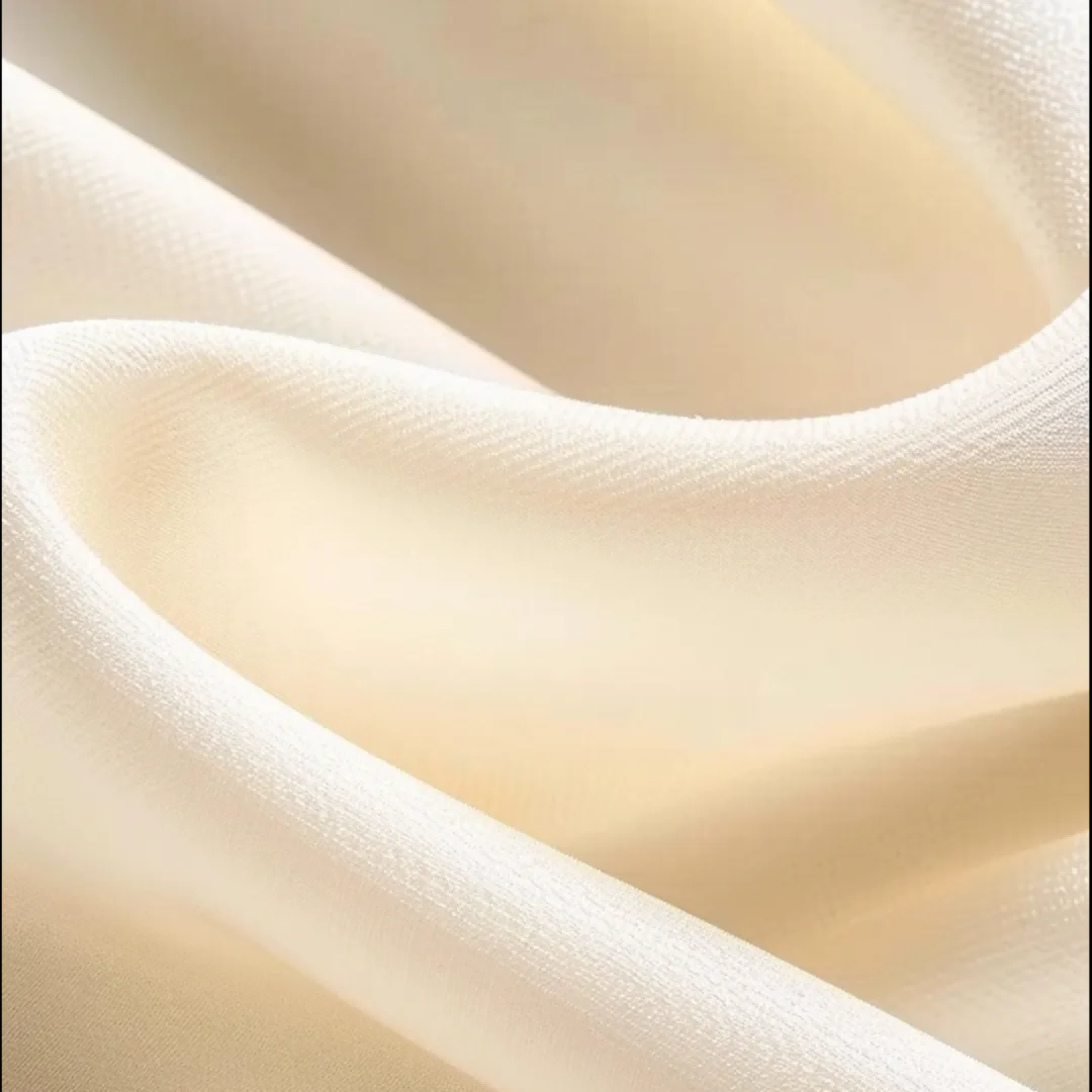 The texture of cream-colored, folded textile fabric, suggesting a sense of comfort and quality.