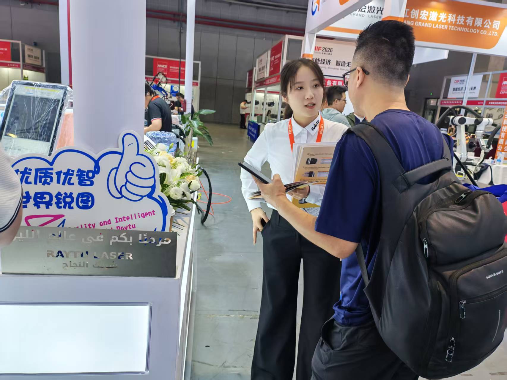 Raytu team member reviewing information with a visitor at the exhibition booth.jpg