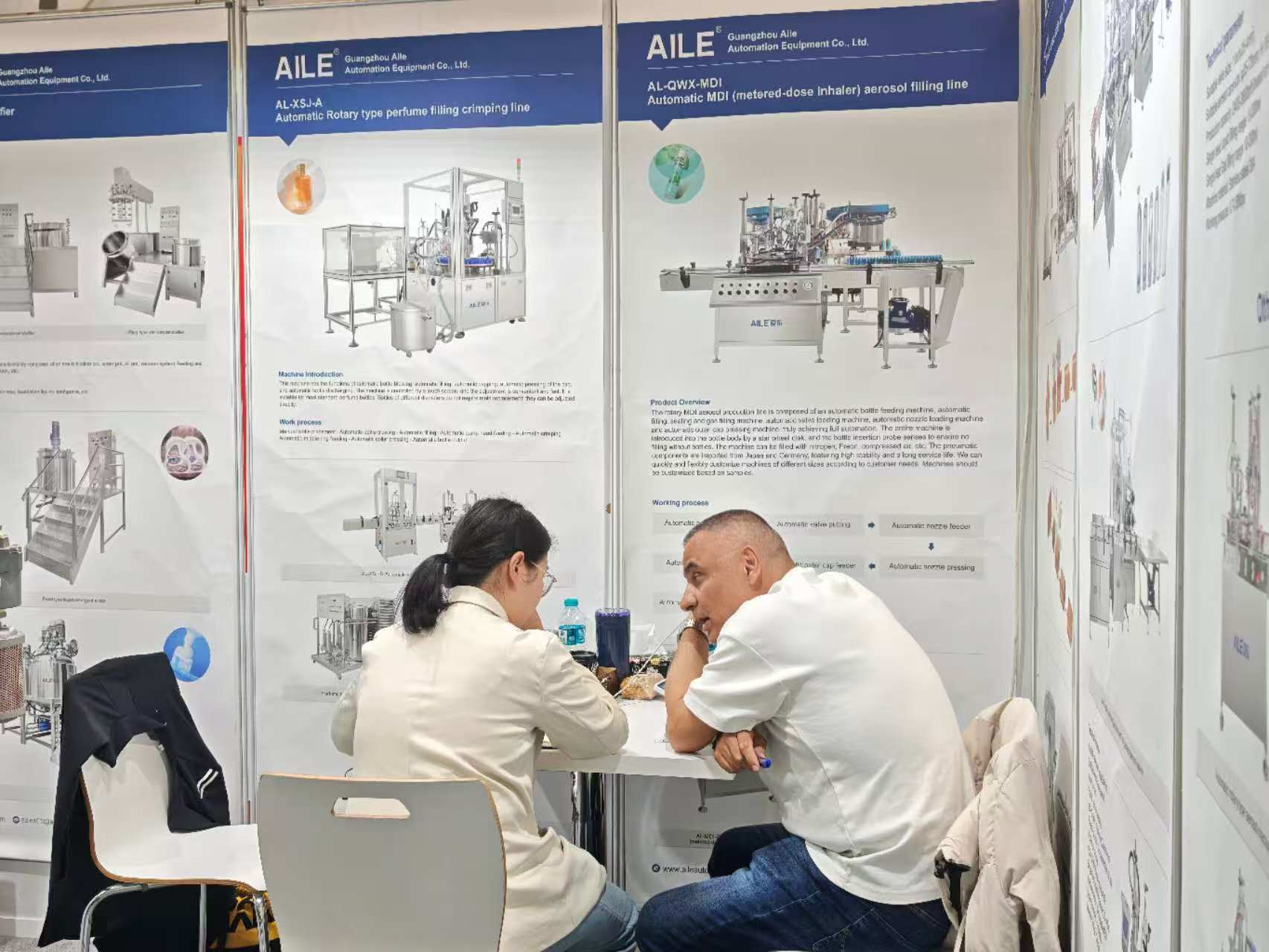 AILE team talking with a client at the booth