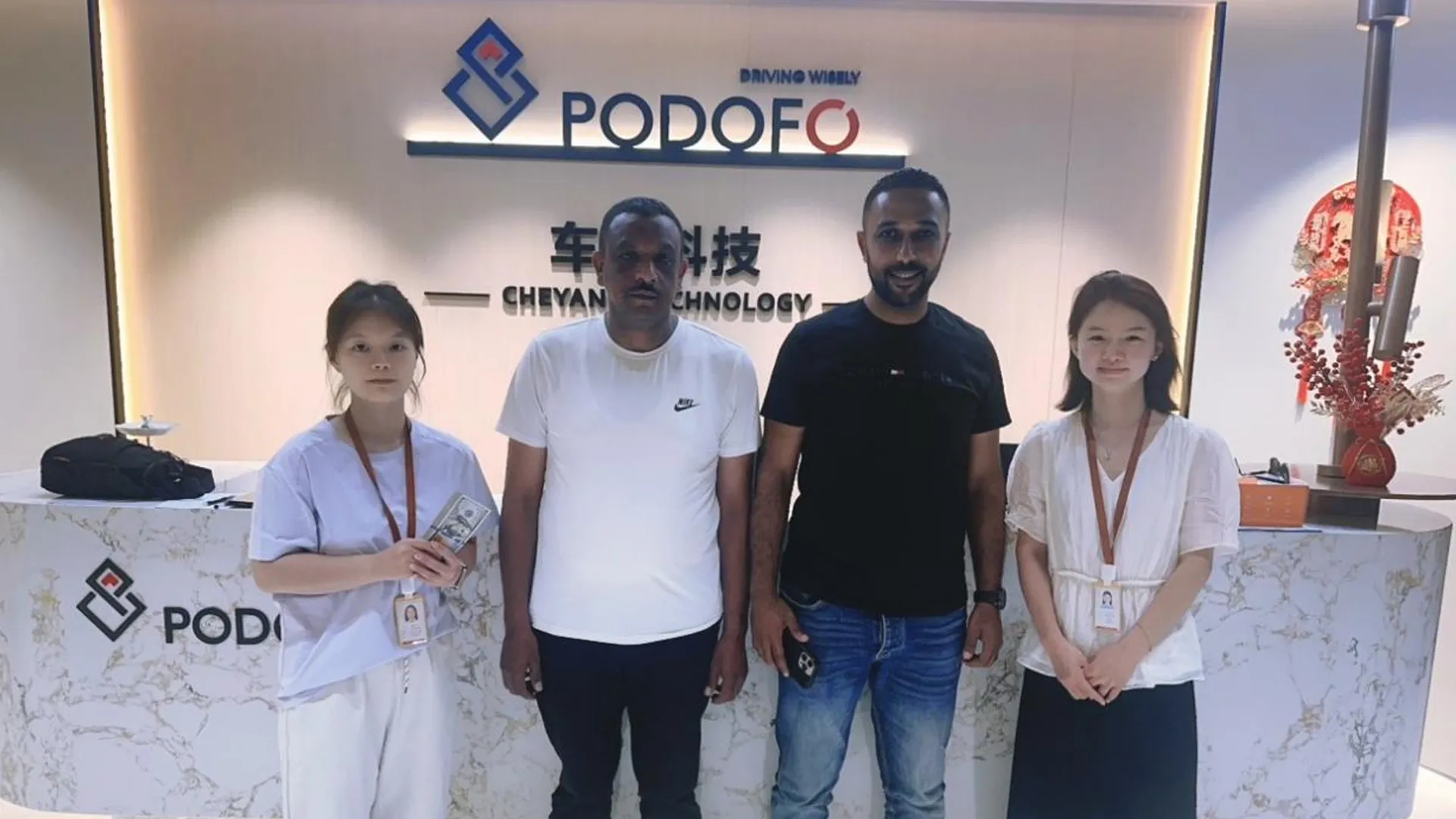 Customer visit group photo at reception desk.webp