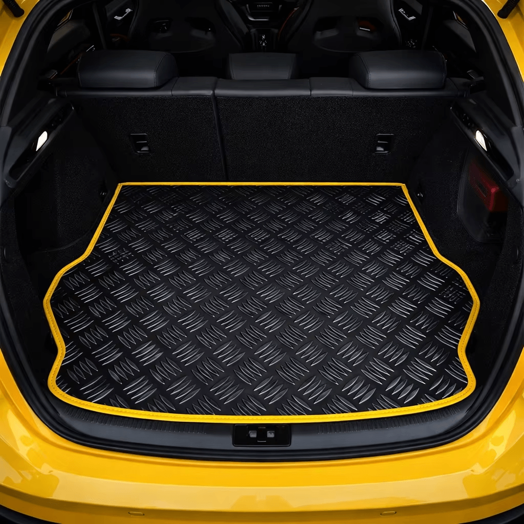PVC trunk mat with black diamond plate texture and yellow edge trim fitted in a car cargo area