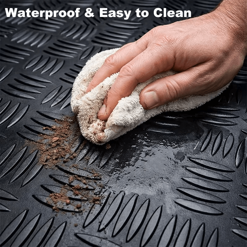 Waterproof PVC trunk mat with diamond plate texture being wiped clean to remove water, mud and dirt