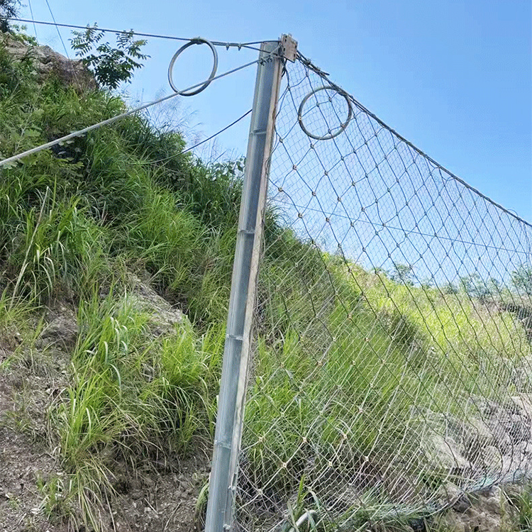 How does a slope protection net prevent rockfalls on mountainous roads?