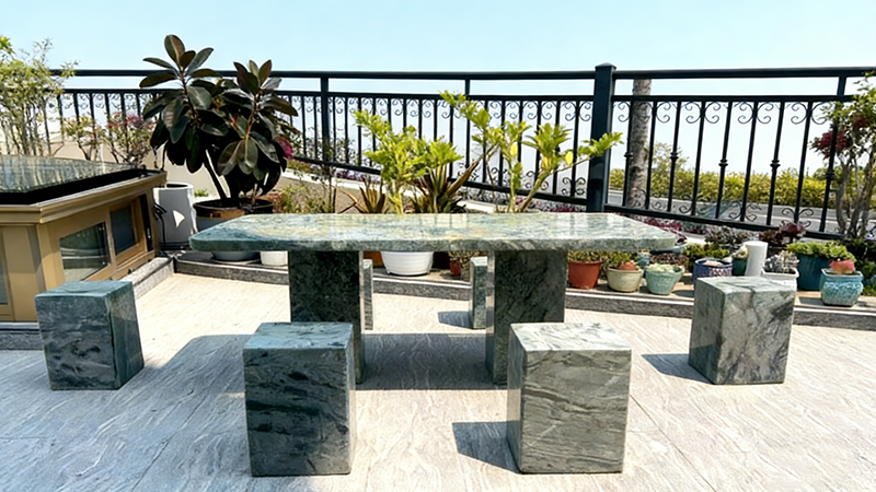 Green marble outdoor dining set (table and stools) placed on a patio, surrounded by potted plants for a natural, relaxing outdoor living space.png