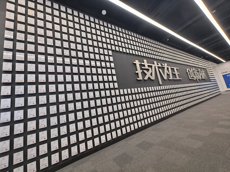 Wall of certificates at BYD enterprise exhibition area, displaying numerous certification documents alongside the slogan Technology is King, Innovation is Fundamental.jpg