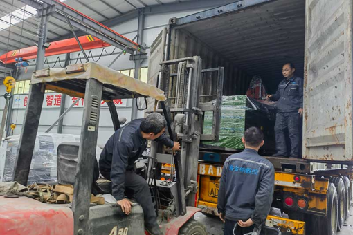 Rain Falls Outside as Workers Stay Busy in Workshop; Two Containers of Equipment Shipped Today, Next Container Headed to India