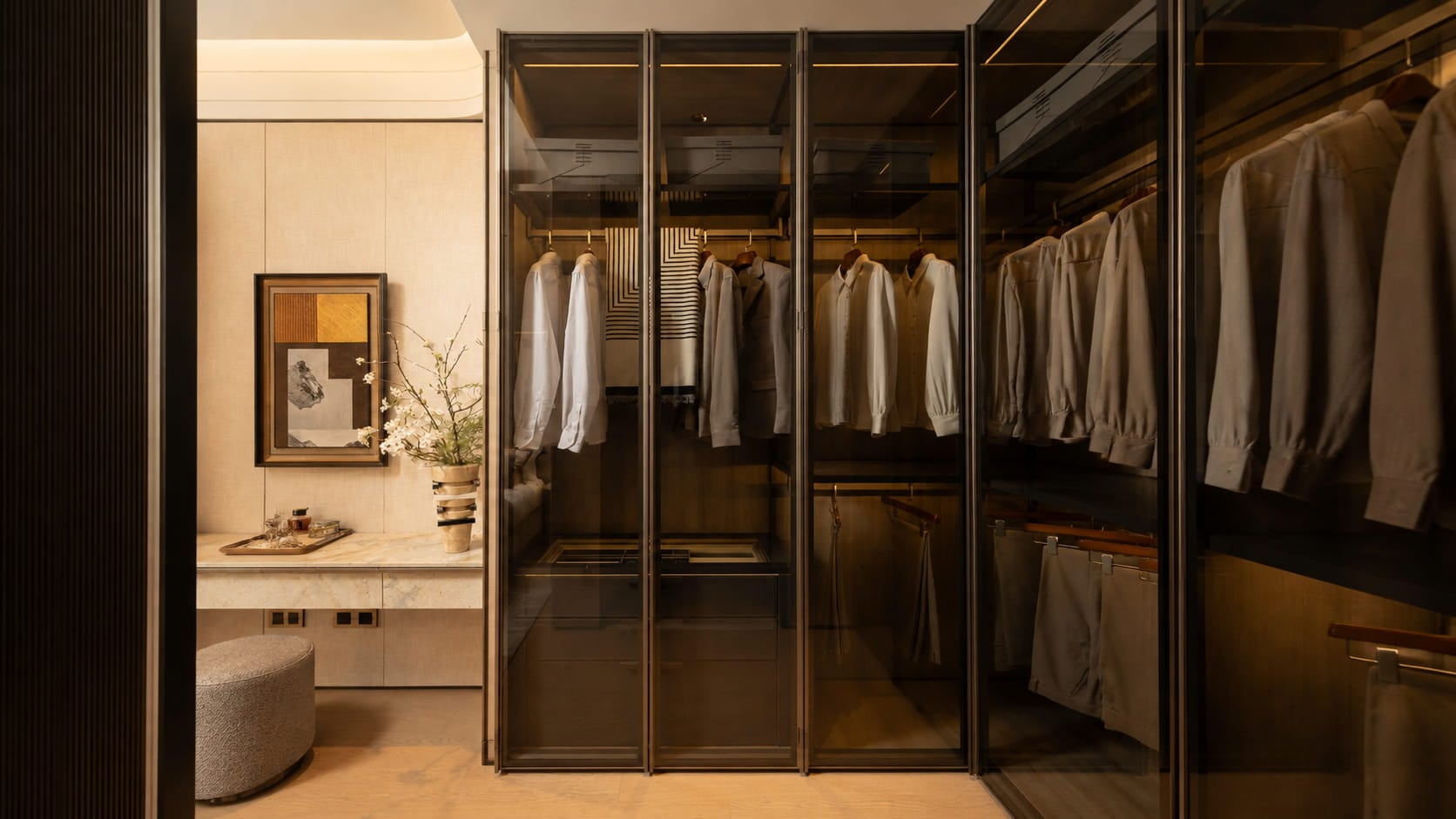 Bronze-tinted glass aluminium wardrobe with slim dark frames and warm interior lighting