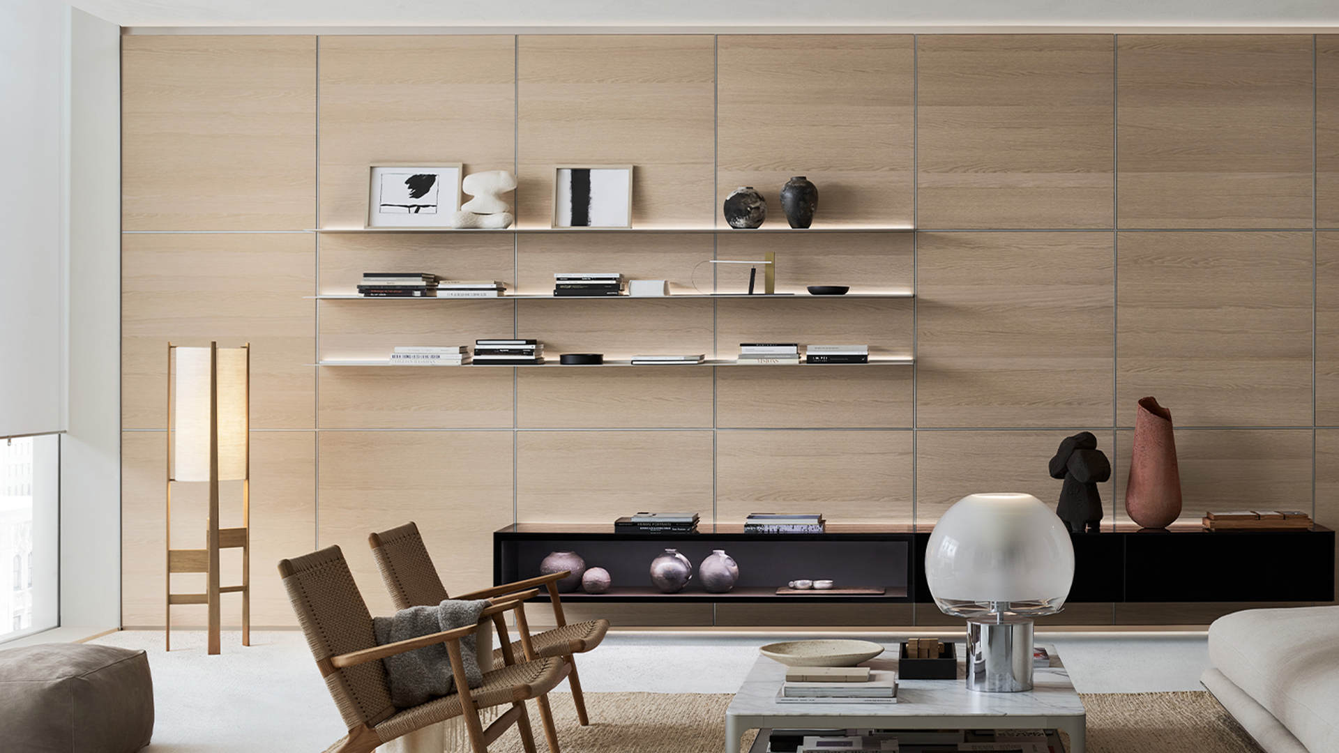 Illuminated floating aluminum shelves integrated into a wood wall panel and base cabinet composition