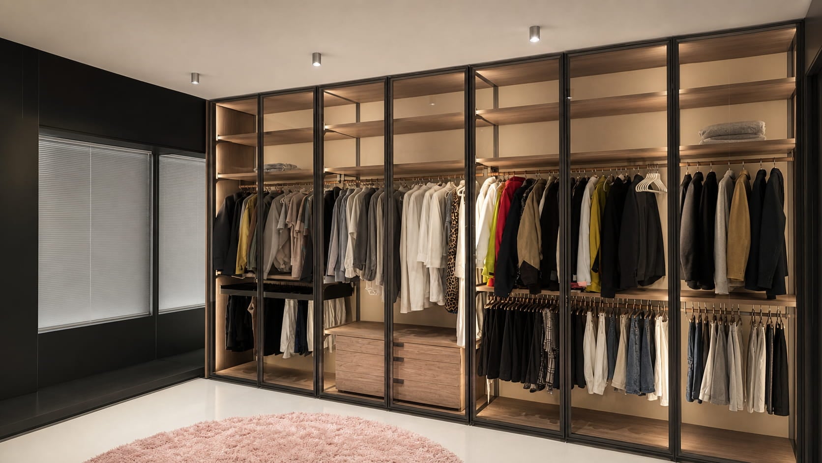 Completed wall-to-wall aluminum-framed glass wardrobe installation with warm wood interiors and integrated LED lighting