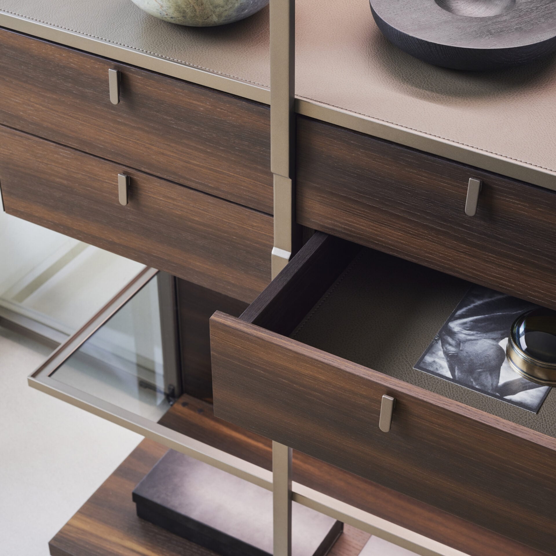 Walnut-finish drawers leather-detail top and compact metal handles in a luxury display cabinet