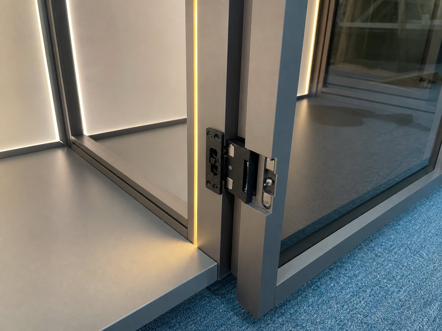 Close-up of an aluminum wardrobe frame hinge connection and integrated LED lighting