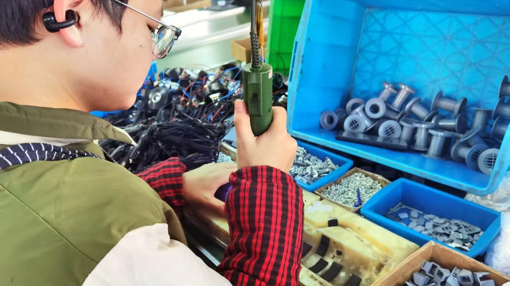 Assembly line technician hand-assembling Fitco tire inflator units