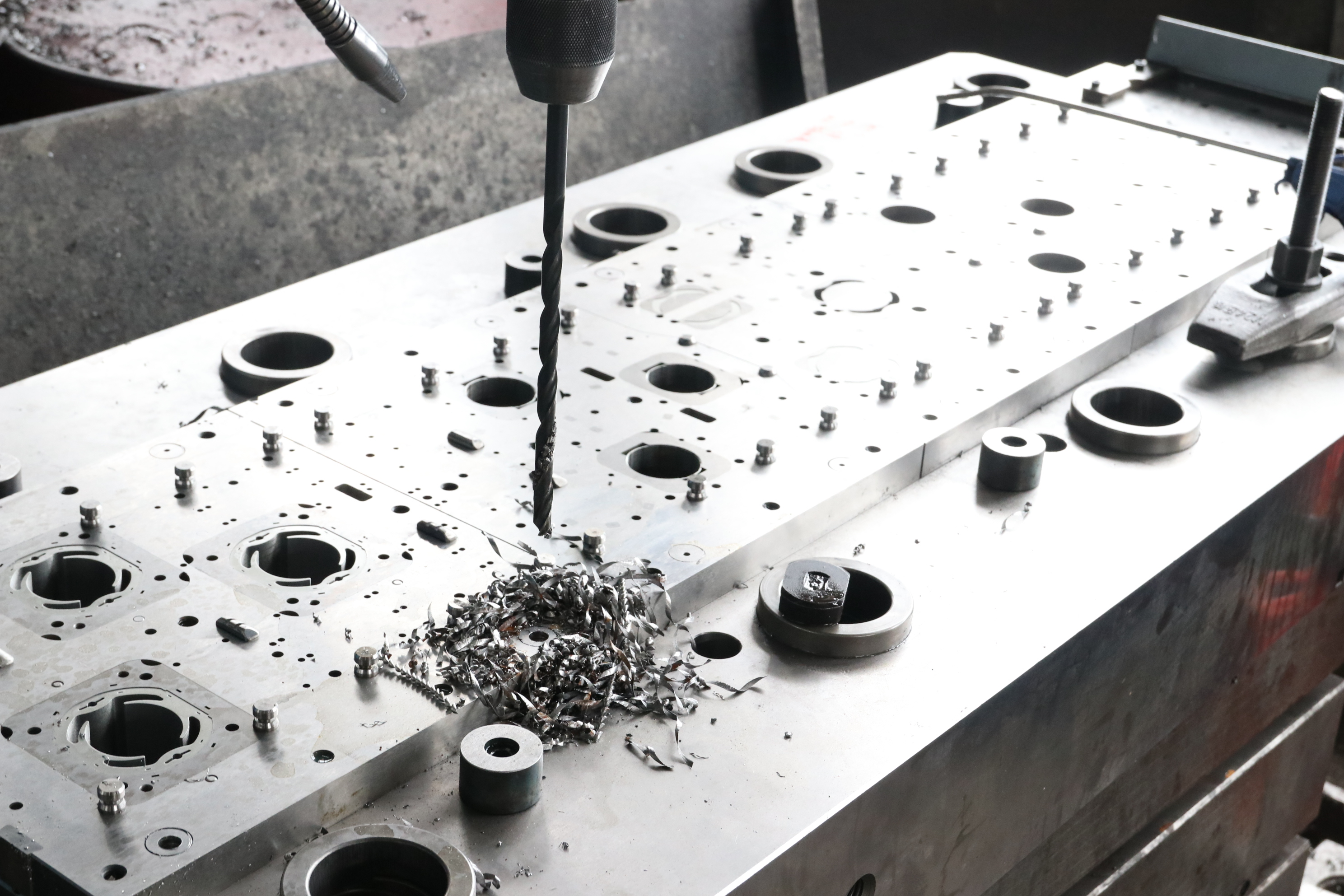 Progressive die strip layout and tooling design for precision automotive compressor brackets