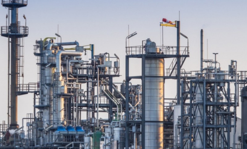 Molybdenum-enhanced stainless steel piping in a refinery unit handling warm, corrosive process streams