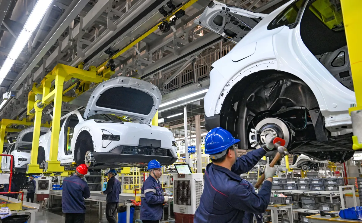 At a Changan Automobile factory, workers operate on the chassis assembly line.
