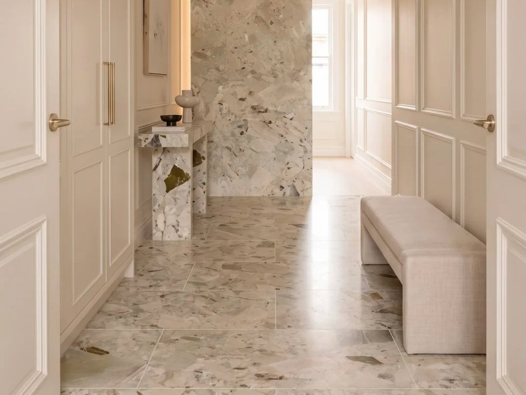 Monet Garden Marble flooring and console in a bright entrance hall with warm cream wall panels.