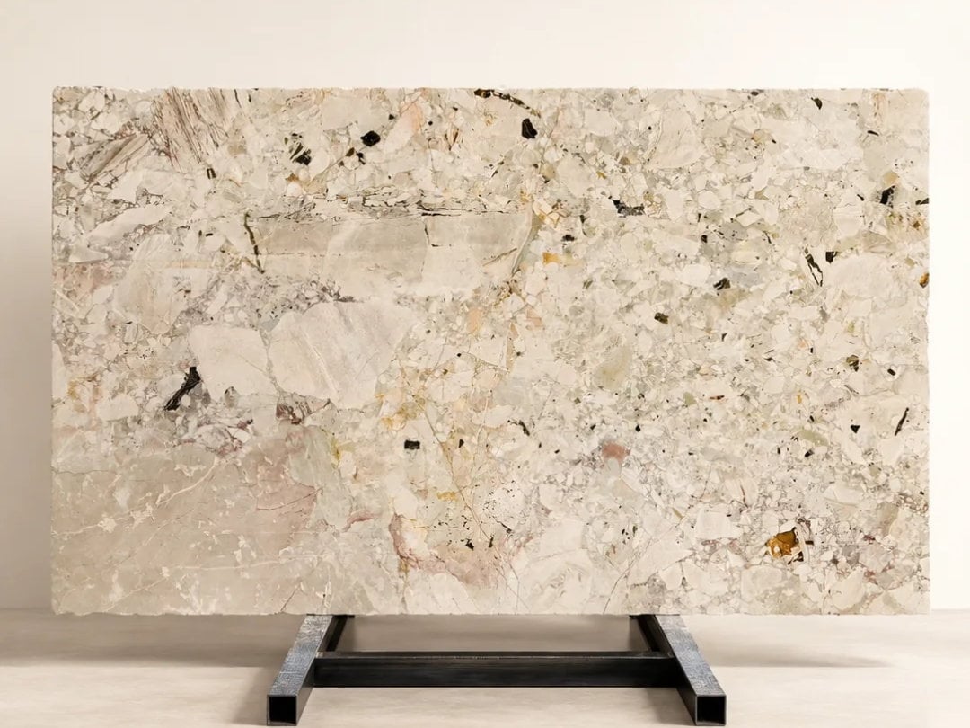 Monet Garden Marble slab with soft cream, blush pink, green, grey, and dark mineral fragments.